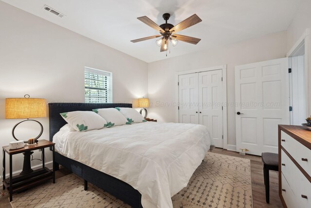 bedroom with visible vents, wood finished floors, ceiling fan, and a closet