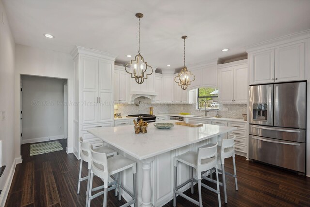 kitchen featuring an inviting chandelier, dark wood-style flooring, decorative backsplash, white cabinets, and appliances with stainless steel finishes