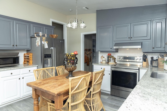 605 W 6th St, Jasper, AL 35501 - kitchen featuring stainless steel appliances, exhaust hood, a chandelier, and light wood-style flooring