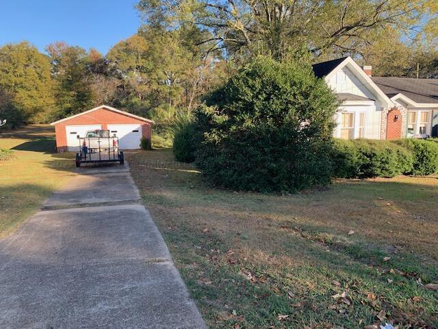 view of side of home featuring a yard, an outdoor structure, and a garage