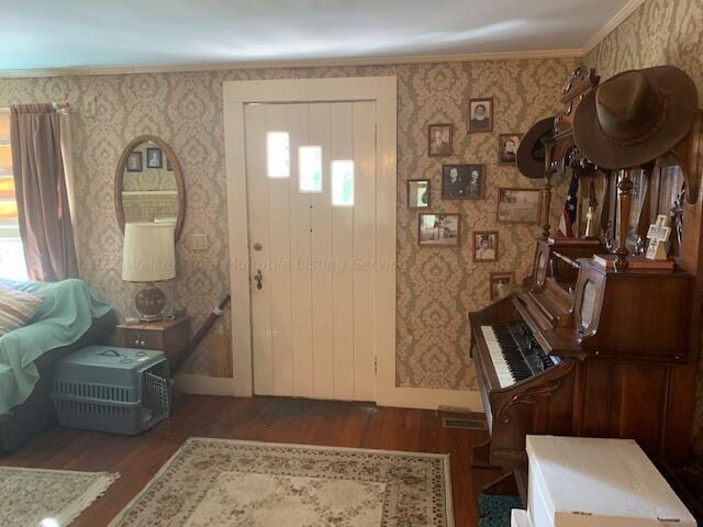 foyer entrance featuring a healthy amount of sunlight, ornamental molding, and dark wood-type flooring