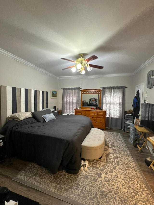 bedroom with ceiling fan, crown molding, and wood finished floors