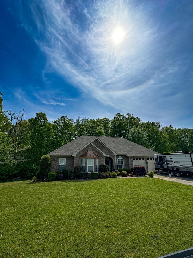 view of front of house with an attached garage, driveway, and a front lawn