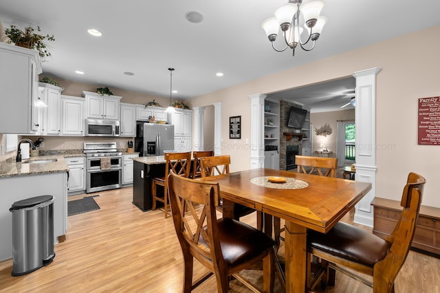 1528 Sipsey Rd, Double Springs, AL 35553 - dining area with light wood-type flooring, a fireplace, a ceiling fan, recessed lighting, and ornate columns