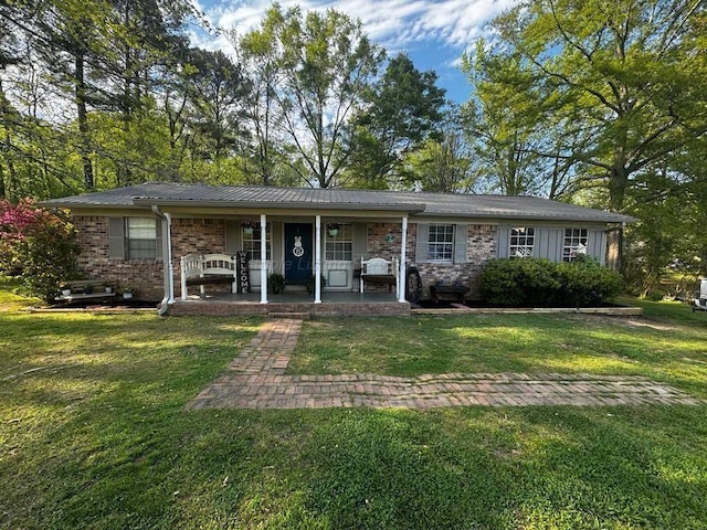 ranch-style house featuring covered porch and a front lawn