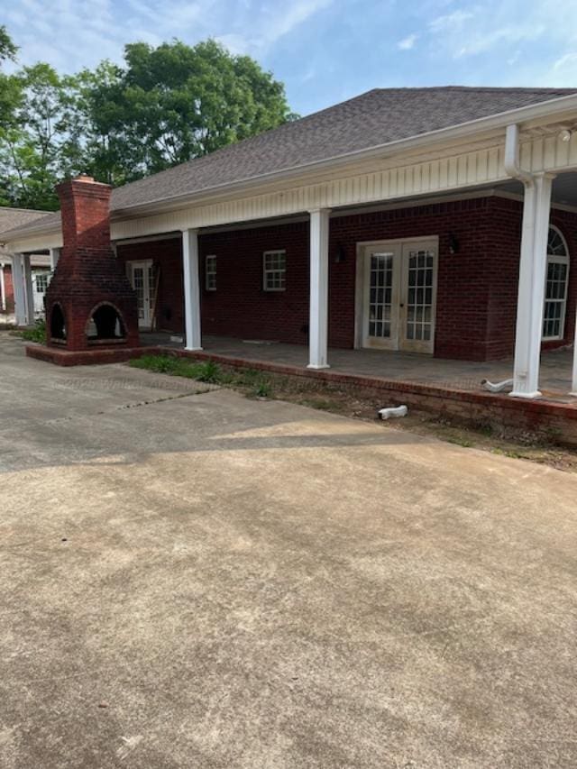 130 Quail Run Dr, Winfield, AL 35594 - view of home's exterior with french doors, brick siding, a shingled roof, a chimney, and a fireplace