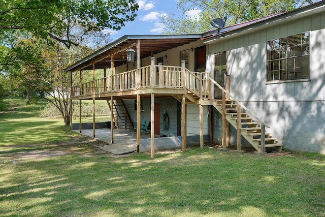 rear view of house featuring a wooden deck, a yard, stairs, and a patio
