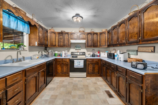 kitchen featuring under cabinet range hood, a textured ceiling, a sink, and black appliances
