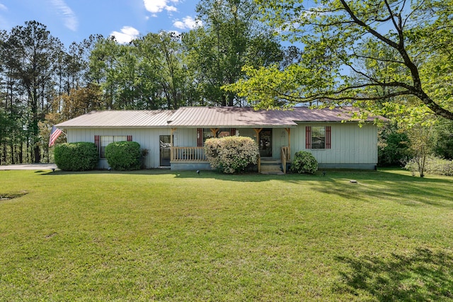 single story home with a porch, a front lawn, and metal roof