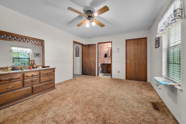 bedroom with carpet floors, visible vents, ceiling fan, and connected bathroom