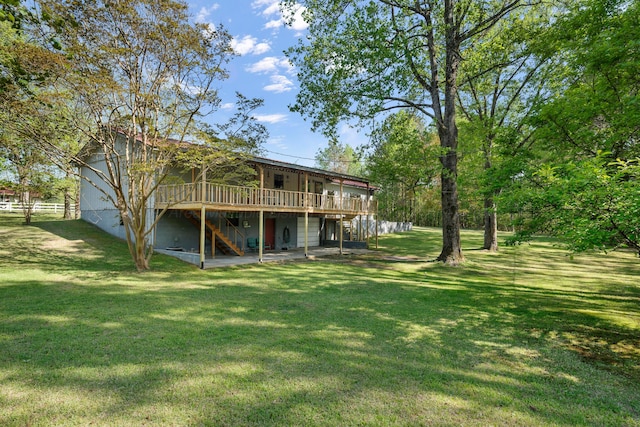 rear view of property featuring a lawn, stairs, and a deck