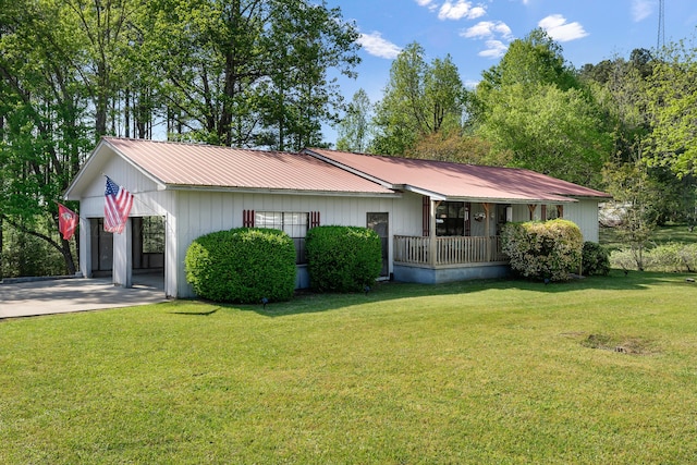 ranch-style home with concrete driveway, a front lawn, a carport, a porch, and metal roof
