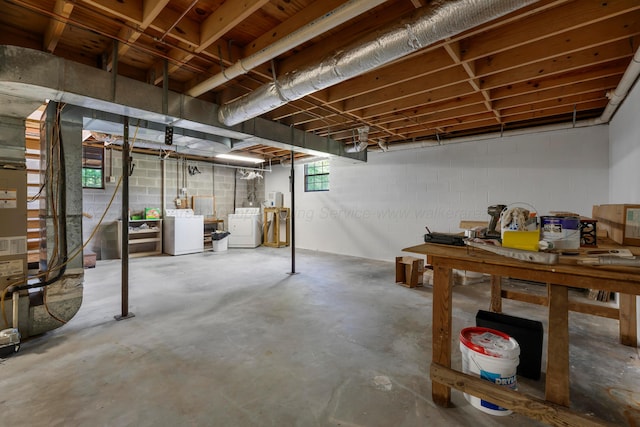 below grade area featuring separate washer and dryer and concrete block wall