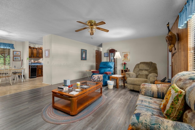 living room featuring a ceiling fan, wood finished floors, and a textured ceiling