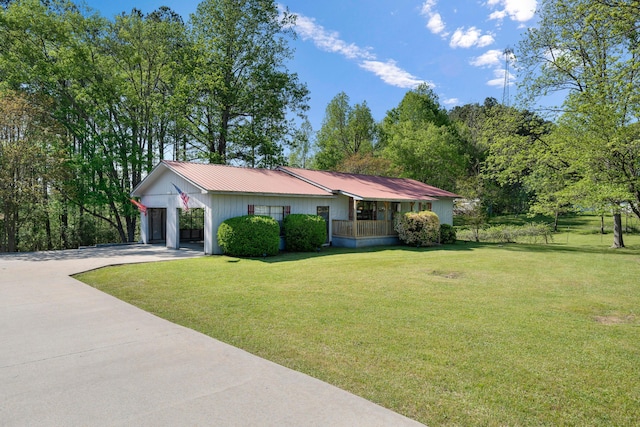single story home with metal roof, a front lawn, concrete driveway, and an attached carport