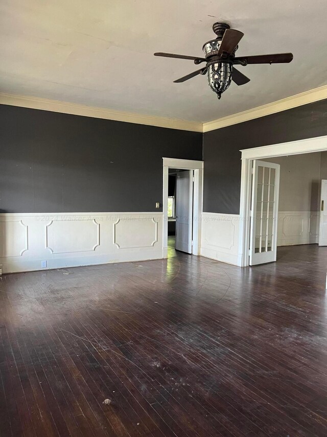 spare room featuring ceiling fan, a decorative wall, crown molding, and hardwood / wood-style flooring