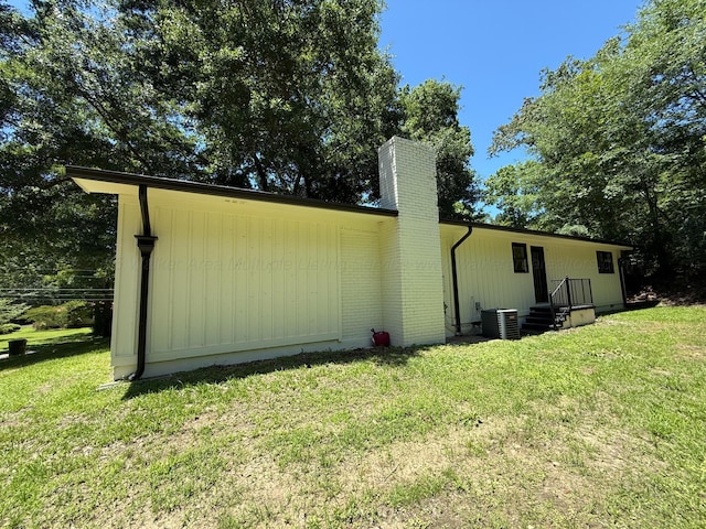 2301 E 20th Ave, Jasper, AL 35501 - view of side of home with a chimney, a yard, and central air condition unit