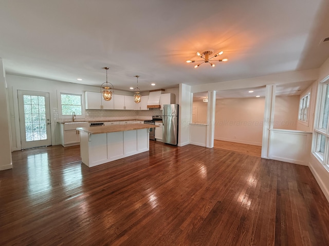 2301 E 20th Ave, Jasper, AL 35501 - kitchen with appliances with stainless steel finishes, a kitchen island, white cabinetry, dark wood-style flooring, and tasteful backsplash
