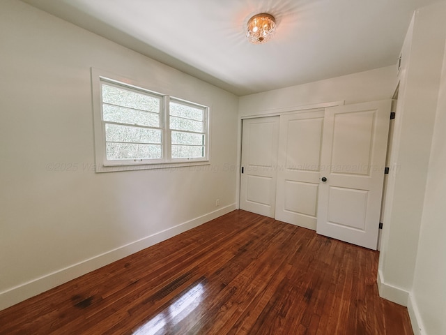 2301 E 20th Ave, Jasper, AL 35501 - unfurnished bedroom with dark wood-style flooring, baseboards, and a closet
