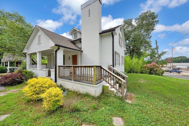 809 W 15th St, Jasper, AL 35501 - view of property exterior featuring a porch, a chimney, a yard, and roof with shingles