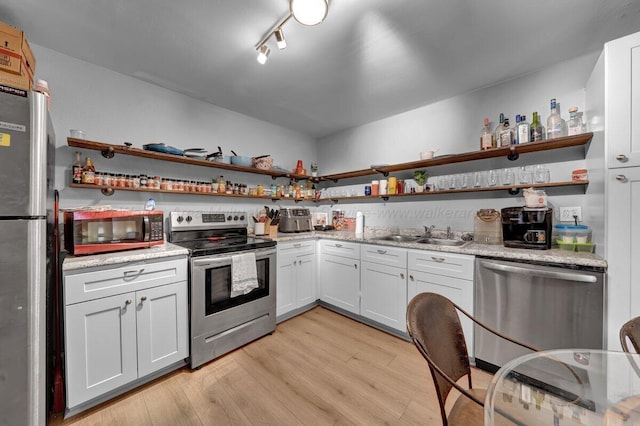 809 W 15th St, Jasper, AL 35501 - kitchen with appliances with stainless steel finishes, open shelves, light wood-style floors, white cabinetry, and light stone countertops