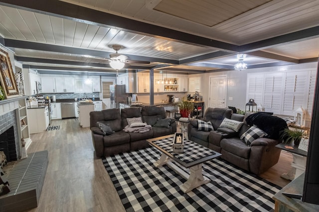 1602 27th St, Haleyville, AL 35565 - living room featuring light wood-style floors, a fireplace, ceiling fan, and a wooden ceiling with exposed beams