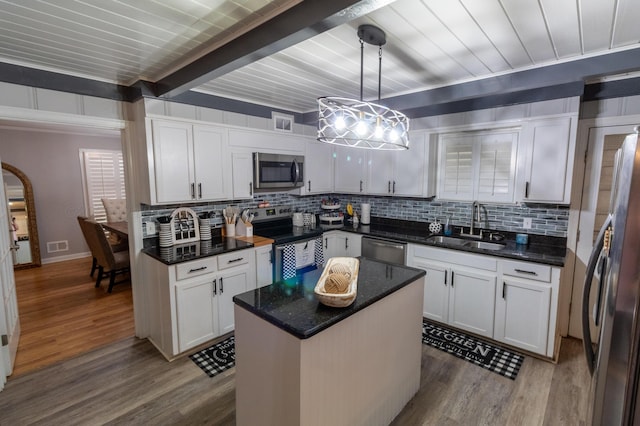 1602 27th St, Haleyville, AL 35565 - kitchen featuring stainless steel appliances, decorative backsplash, crown molding, wood finished floors, and white cabinetry
