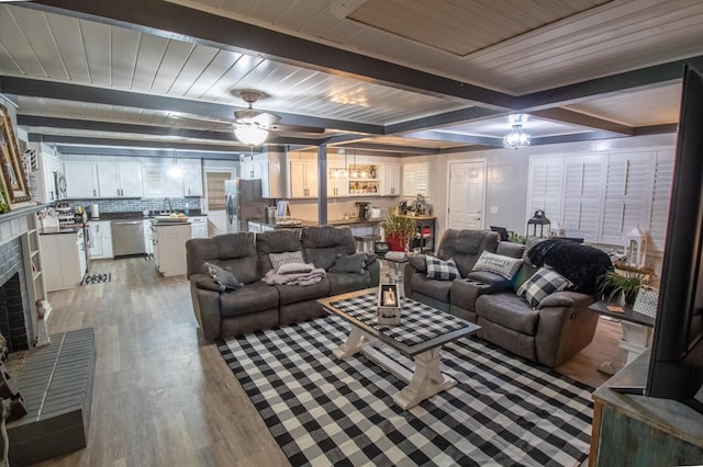 1602 27th St, Haleyville, AL 35565 - living room with light wood-type flooring, a brick fireplace, a ceiling fan, and a wood ceiling with exposed beams