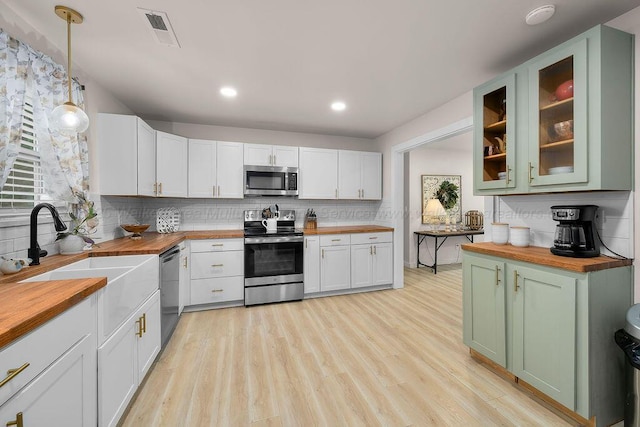 69 Oak Dr, Jasper, AL 35501 - kitchen with wood counters, stainless steel appliances, light wood finished floors, backsplash, and glass insert cabinets