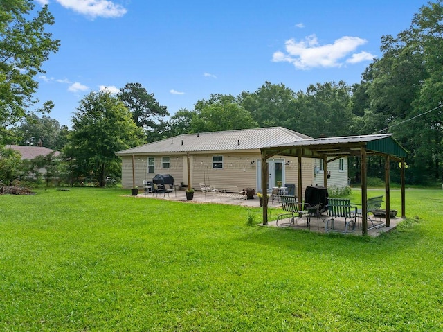 69 Oak Dr, Jasper, AL 35501 - rear view of house with a patio, a lawn, and a metal roof