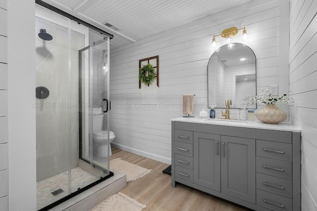 69 Oak Dr, Jasper, AL 35501 - bathroom featuring vanity, wood finished floors, a shower stall, and wood walls