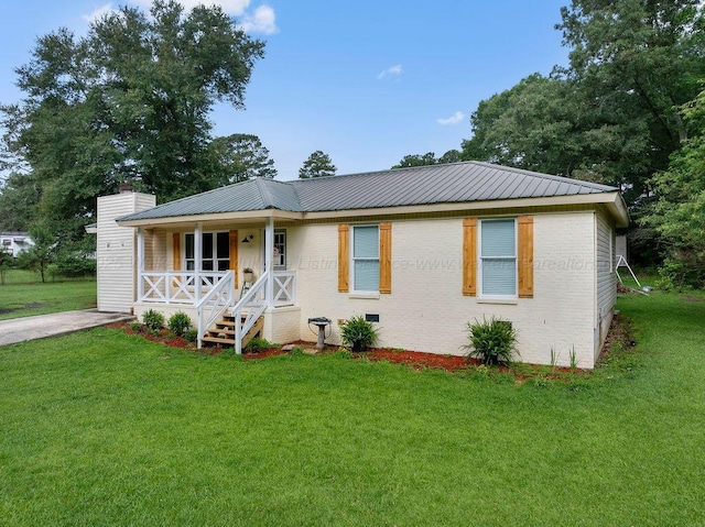 69 Oak Dr, Jasper, AL 35501 - view of front of house with covered porch, brick siding, a front lawn, and a chimney