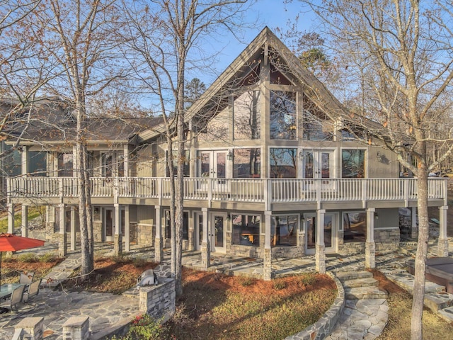 rear view of property with french doors and stone siding