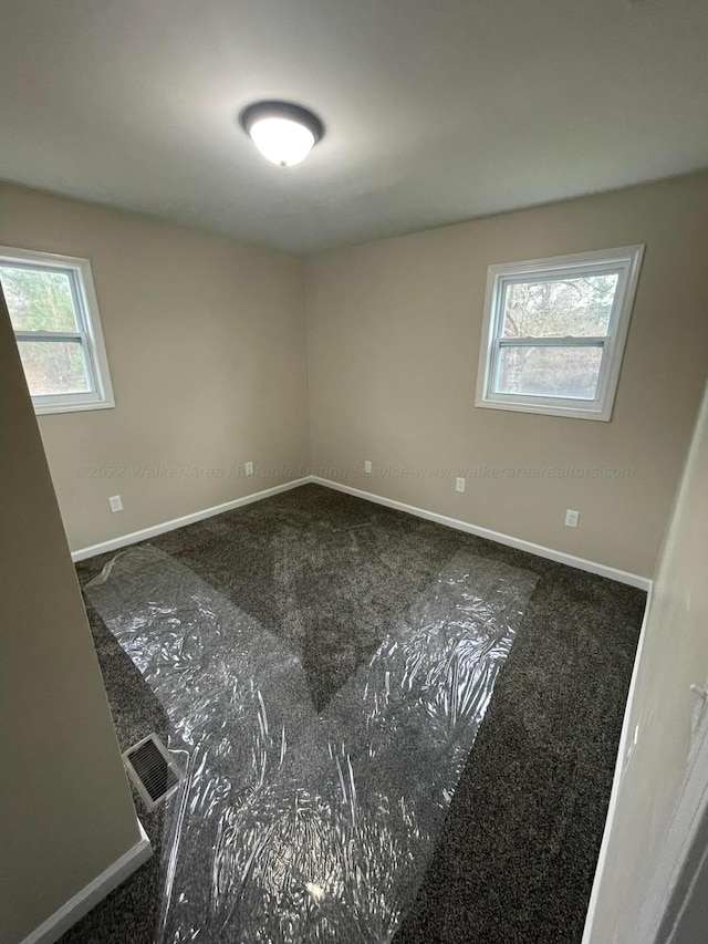 spare room featuring baseboards and visible vents