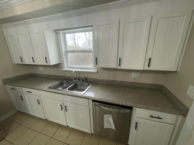 kitchen featuring white cabinets, a sink, dark countertops, and stainless steel dishwasher
