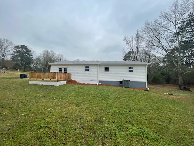 rear view of house with central AC unit, a yard, and a wooden deck