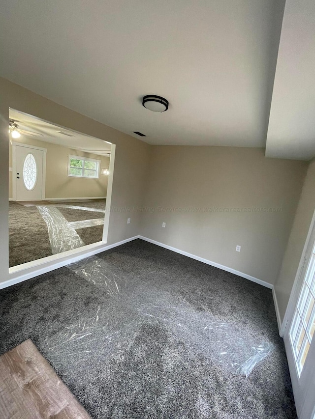 carpeted spare room featuring baseboards