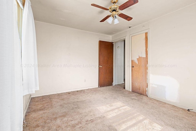 carpeted spare room featuring ceiling fan