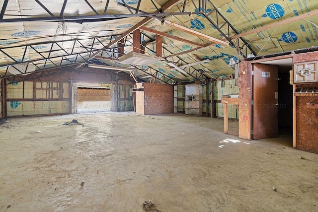 misc room featuring lofted ceiling and concrete flooring