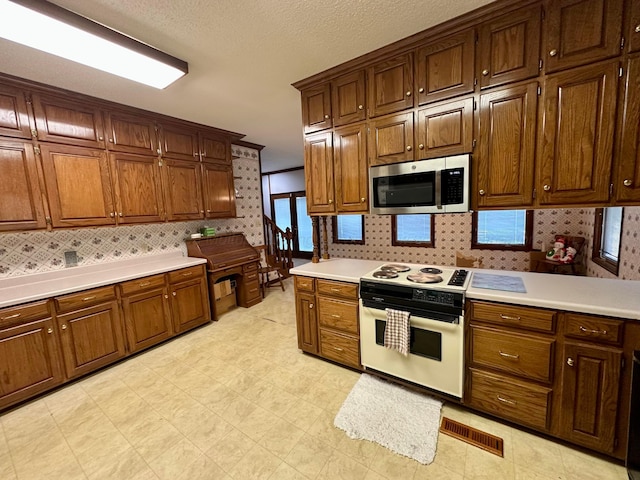 542 Llama Ln, Quinton, AL 35130 - kitchen featuring stainless steel microwave, electric range, light countertops, and decorative backsplash