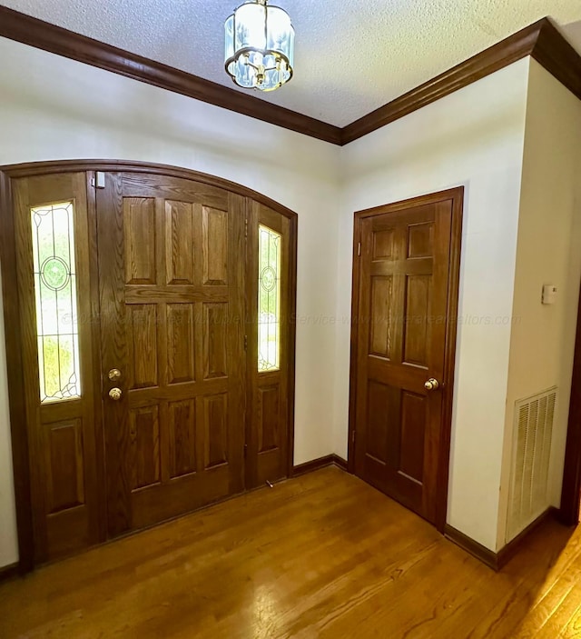 542 Llama Ln, Quinton, AL 35130 - entrance foyer featuring ornamental molding, wood finished floors, a chandelier, a textured ceiling, and arched walkways