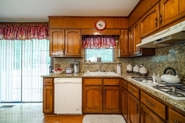 1925 Sharon Blvd, Dora, AL 35062 - kitchen featuring white appliances, a sink, under cabinet range hood, brown cabinetry, and tasteful backsplash