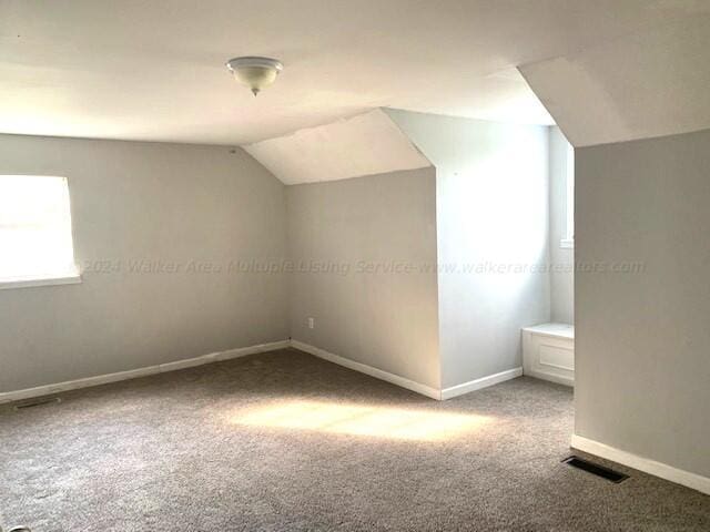 bonus room featuring carpet floors, baseboards, vaulted ceiling, and visible vents