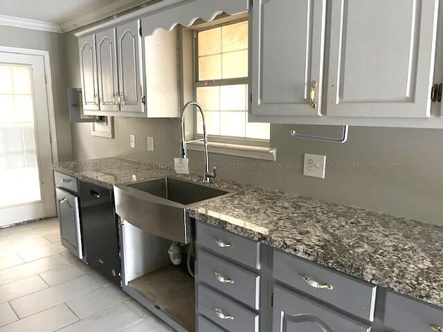 kitchen with gray cabinetry, black dishwasher, a sink, and a wealth of natural light