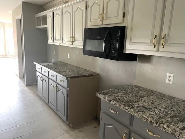 kitchen with black microwave and stone counters