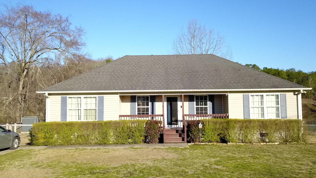 single story home with a front yard, a porch, and roof with shingles