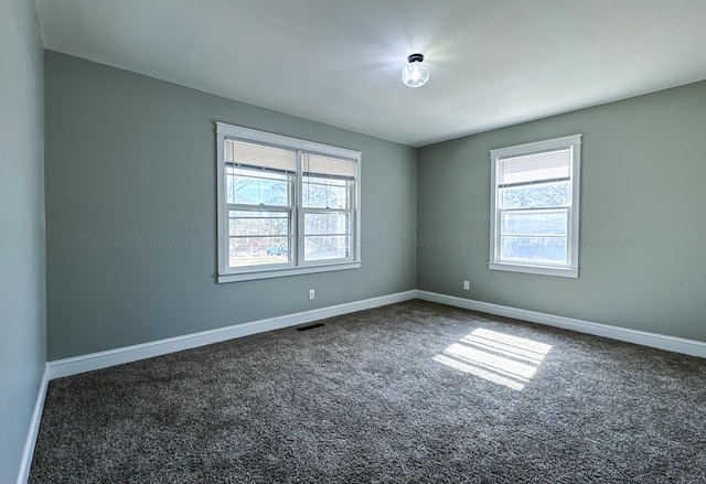 carpeted spare room featuring baseboards and visible vents