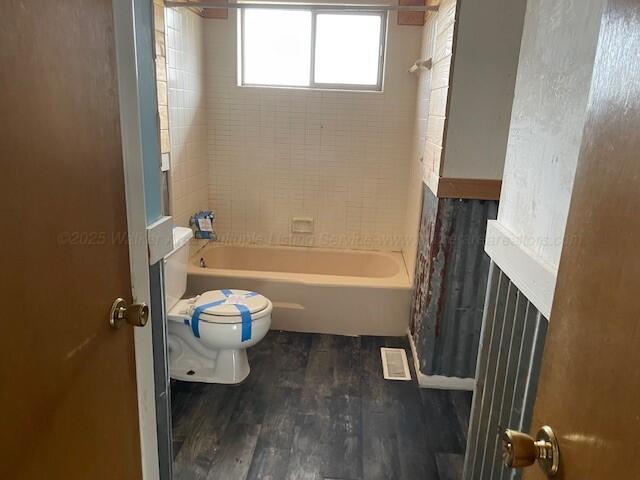 full bathroom featuring toilet, shower / bathtub combination, and wood finished floors