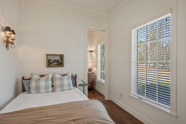 bedroom featuring dark wood-type flooring, crown molding, and baseboards