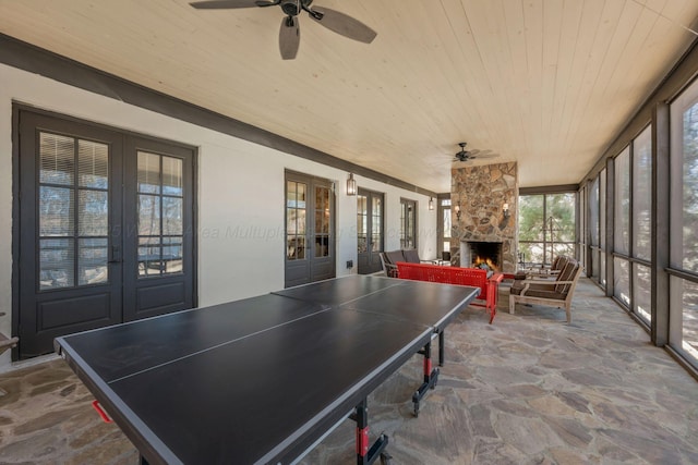 rec room with wood ceiling, french doors, stone floors, and ceiling fan